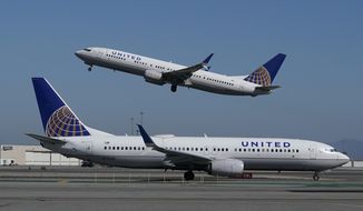 In this Oct. 15, 2020, file photo, a United Airlines airplane takes off over a plane on the runway at San Francisco International Airport in San Francisco. (AP Photo/Jeff Chiu, File)