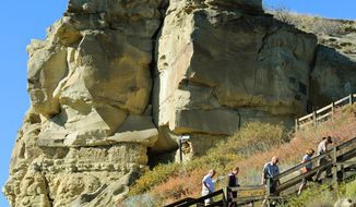Tourists make their way up the stairs to William Clark&#39;s signature at Pompeys Pillar along the Lewis and Clark Trail in southeastern Montana in 2014. The U.S. Bureau of Land Management is proposing work to keep the historic sandstone landmark near the Yellowstone River east of Billings from falling apart or eroding further. The sandstone is also engraved with over 5,000 other etchings, petroglyphs and pictographs, according to the National Park Service. (Larry Mayer/The Billings Gazette via AP)