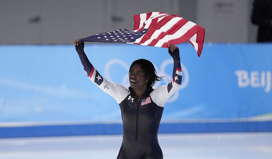 Erin Jackson of the United States hoists an American flag after winning the gold medal in the speedskating women&#x27;s 500-meter race at the 2022 Winter Olympics, Sunday, Feb. 13, 2022, in Beijing. (AP Photo/Sue Ogrocki)
