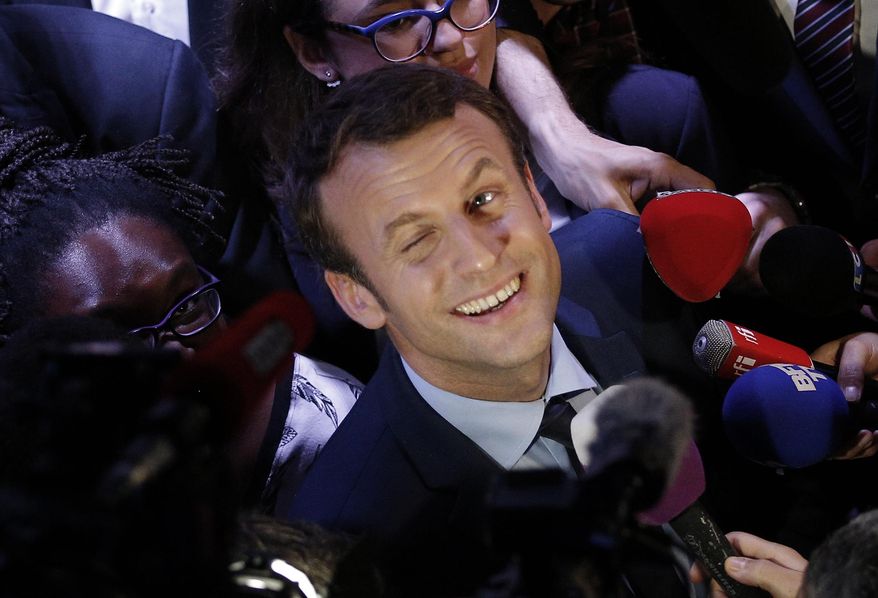 Then Independent centrist presidential candidate Emmanuel Macron smiles to the media after a meeting with young people of Paris suburbs, in Saint Denis, outside Paris, March 30, 2017. French President Emmanuel Macron hasn’t officially declared that he’s a candidate for April’s presidential election yet. But he already has a full campaign team and makes speeches about his plans for the country in the upcoming years. Critics say he’s unfairly using his taxpayer-funded presidential pulpit to campaign for a second term while dragging out his widely expected announcement as long as possible. (AP Photo/Christophe Ena, File)
