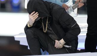 Eminem kneels down during the halftime performance at the NFL Super Bowl 56 football game between the Los Angeles Rams and the Cincinnati Bengals Sunday, Feb. 13, 2022, in Inglewood, Calif. (AP Photo/Chris O&#39;Meara)