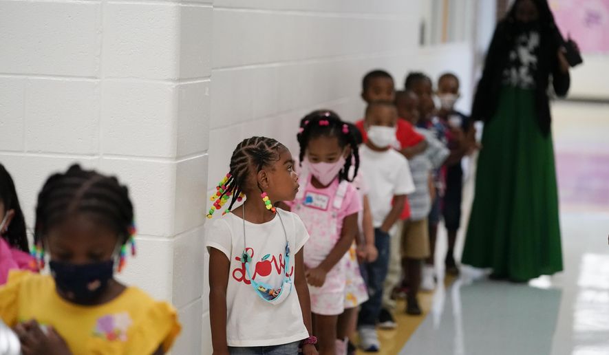 Students walk down the hallway at Tussahaw Elementary school on Wednesday, Aug. 4, 2021, in McDonough, Ga., with some in masks and some unmasked. Gov. Brian Kemp on Wednesday, Feb. 9, 2022, said he would propose a law that would let parents opt their students out of masks in Georgia school districts that require them for all students to prevent the spread of COVID-19. (AP Photo/Brynn Anderson, File)