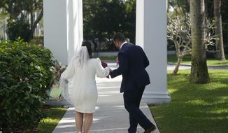 Danielle Green, left, and her new husband Yehonatan Miron dance as they leave after being married during a Valentine&#39;s Day group wedding ceremony, Monday, Feb. 14, 2022, outside the Flagler Museum in Palm Beach, Fla. The pair were one of nine couples married by the Clerk of the Circuit Court &amp;amp; Comptroller for Palm Beach County during the annual event. (AP Photo/Wilfredo Lee)