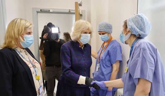 Britain&#39;s Camilla, the Duchess of Cornwall, center, meets members of staff, during her visit to Paddington Haven, a sexual assault referral centre in West London, Thursday, Feb. 10, 2022. Camilla has tested positive for COVID-19, four days after her husband Prince Charles was diagnosed with the virus. The couple’s office said Monday, Feb. 14, 2022 that Camilla is self-isolating. Charles has been isolating since he tested positive on Thursday, but Camilla had continued with public engagements while taking daily tests. (Tolga Akmen/Pool Photo via AP, File)