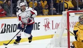 Washington Capitals left wing Alex Ovechkin (8) moves the puck behind the net during the first period of the team&#39;s NHL hockey game against the Nashville Predators, Tuesday, Feb. 15, 2022, in Nashville, Tenn. (AP Photo/Mark Zaleski)