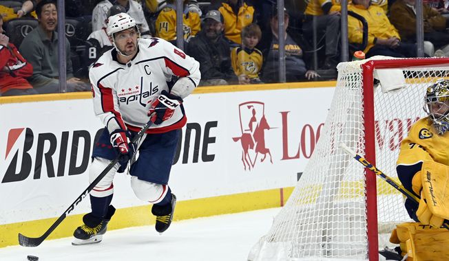 Washington Capitals left wing Alex Ovechkin (8) moves the puck behind the net during the first period of the team&#x27;s NHL hockey game against the Nashville Predators, Tuesday, Feb. 15, 2022, in Nashville, Tenn. (AP Photo/Mark Zaleski)