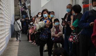 Residents line up to get tested for the coronavirus at a temporary testing center for COVID-19, in Hong Kong, Tuesday, Feb. 15, 2022. Hong Kong&#39;s leader on Tuesday said a surge of coronavirus cases is overwhelming the city&#39;s emergency resources, but defended strict measures that have been imposed. (AP Photo/Kin Cheung)