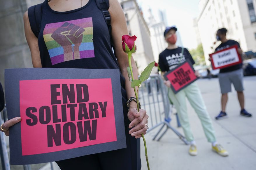 Demonstrators hold signs outside Manhattan criminal court during a march and rally to demand the end of solitary confinement in New York, Monday, June 7, 2021. (AP Photo/Mary Altaffer)