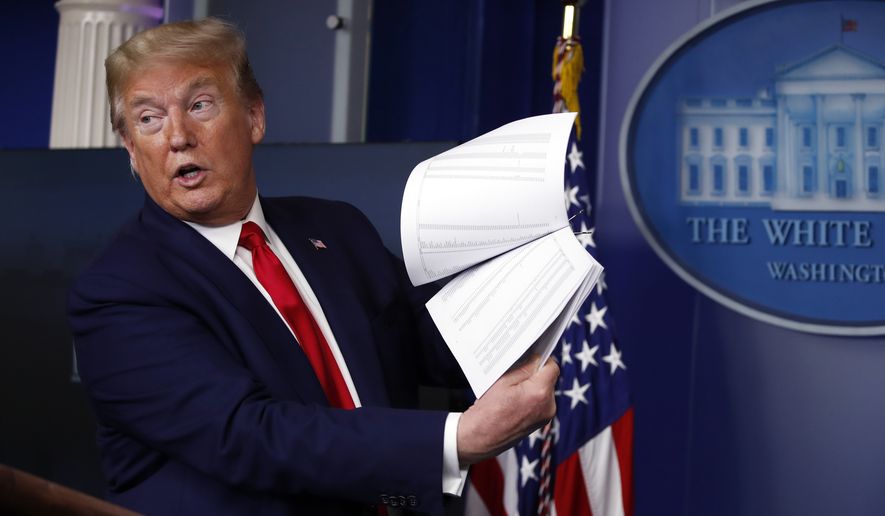 President Donald Trump holds up papers as he speaks about the coronavirus in the James Brady Press Briefing Room of the White House on April 20, 2020, in Washington. (AP Photo/Alex Brandon, File)