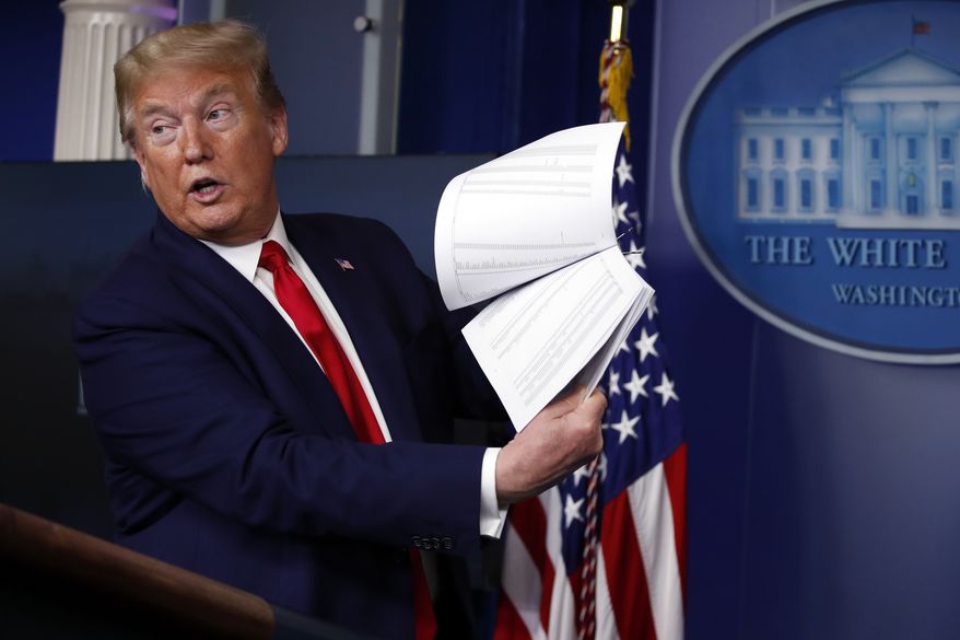 President Donald Trump holds up papers as he speaks about the coronavirus in the James Brady Press Briefing Room of the White House on April 20, 2020, in Washington. (AP Photo/Alex Brandon, File)