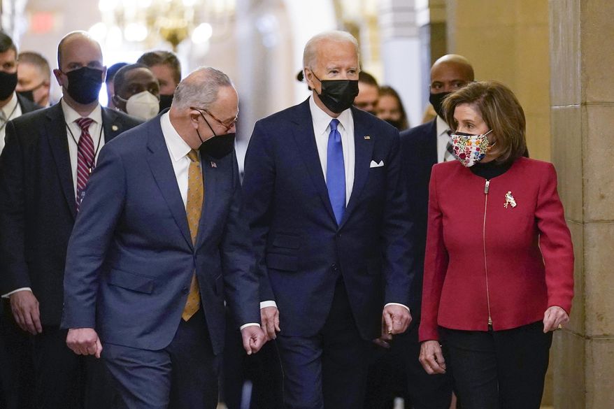 President Joe Biden is flanked by Senate Majority Leader Chuck Schumer of N.Y., left, and House Speaker Nancy Pelosi of Calif., right, after arriving on Capitol Hill in Washington, Jan. 6, 2022.  Biden will give his State of the Union address to Congress on March 1. (AP Photo/Susan Walsh, File)