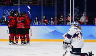 United States goalkeeper Alex Cavallini (33) kneels on the ice as Canada players celebrate after a goal by Marie-Philip Poulin during the women&#39;s gold medal hockey game at the 2022 Winter Olympics, Thursday, Feb. 17, 2022, in Beijing. (AP Photo/Matt Slocum)