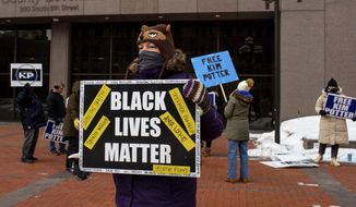 A demonstrator carries a Black Lives Matter sign in front of a group of demonstrators calling for Kim Potter&#39;s release on probation on Friday, Feb. 18, 2022 in Minneapolis. Former suburban Minneapolis police officer Kim Potter was convicted in December of first- and second-degree manslaughter in the April 11 killing of Wright, a Black motorist. (AP Photo/Nicole NerI)