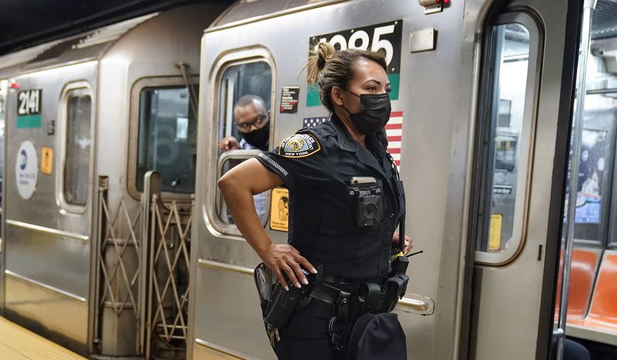 A New York City Police Department officer and a subway conductor look down the subway platform at the Grand Central subway station, in New York, on May 18, 2021. New York Mayor Eric Adams is announcing a plan to boost safety in the city&#x27;s sprawling subway network and try to stop homeless people from sleeping on trains or living in stations. (AP Photo/Frank Franklin II, File)