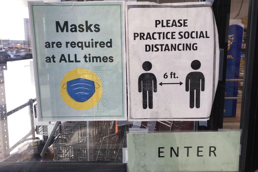 Information signs are displayed at a retail store in Buffalo Grove, Ill., Thursday, Feb. 10, 2022. Illinois Gov. JB Pritzker announced plans that Illinois' mask mandate to be lifted Feb. 28 with exceptions for schools, hospitals, nursing homes. (AP Photo/Nam Y. Huh)