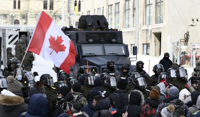 Police, including riot control officers and an armored vehicle, continue to take action to put an end to a protest in Ottawa, Saturday, Feb. 19, 2022. (Justin Tang/The Canadian Press via AP) ** FILE **