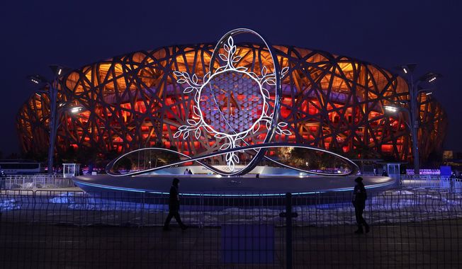 The Olympic flame burning in the center of the snowflake-shaped cauldron is on display near the National Stadium at the 2022 Winter Olympics, Thursday, Feb. 17, 2022, in Beijing. (AP Photo/Jae C. Hong)