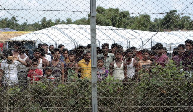 Rohingya refugees gather near a fence during a government-organized media tour, to a no-man&#x27;s land between Myanmar and Bangladesh, near Taungpyolatyar village, Maung Daw, northern Rakhine State, Myanmar, June 29, 2018. An international case accusing Myanmar of genocide against the Rohingya ethnic minority returns to the United Nations&#x27; highest court Monday, Feb. 21, 2022, amid questions over whether the country&#x27;s military rulers should even be allowed to represent the Southeast Asian nation. (AP Photo/Min Kyi Thein, File)