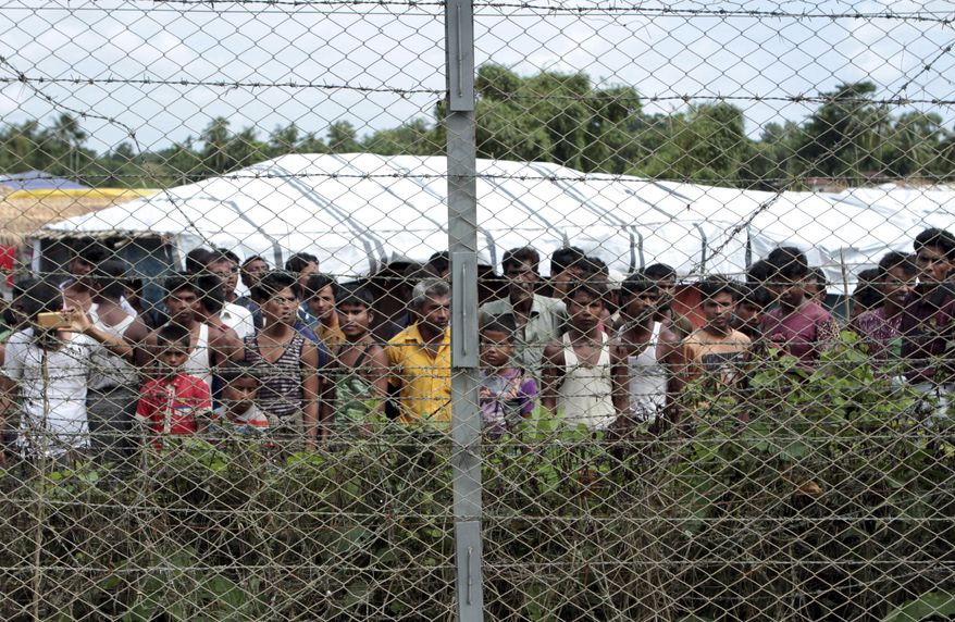 Rohingya refugees gather near a fence during a government-organized media tour, to a no-man&#39;s land between Myanmar and Bangladesh, near Taungpyolatyar village, Maung Daw, northern Rakhine State, Myanmar, June 29, 2018. An international case accusing Myanmar of genocide against the Rohingya ethnic minority returns to the United Nations&#39; highest court Monday, Feb. 21, 2022, amid questions over whether the country&#39;s military rulers should even be allowed to represent the Southeast Asian nation. (AP Photo/Min Kyi Thein, File)