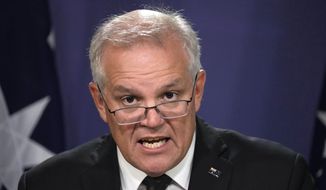 Australian Prime Minister Scott Morrison talks about the situation in Ukraine at a news conference in Sydney, Wednesday, Feb. 23, 2022. Morrison says targeted financial sanctions and travel bans would be the first measures in response to Russian aggression toward Ukraine. (AP Photo/Rick Rycroft)