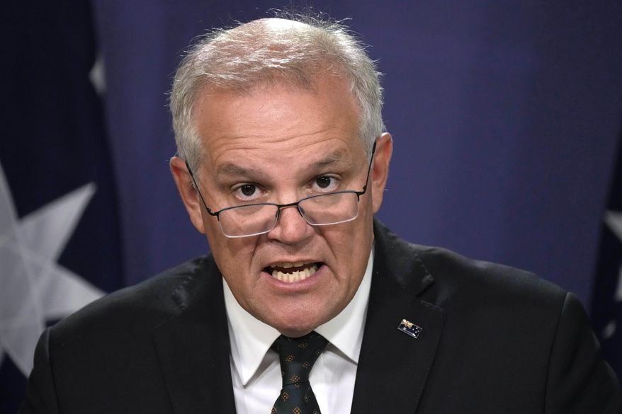 Australian Prime Minister Scott Morrison talks about the situation in Ukraine at a news conference in Sydney, Wednesday, Feb. 23, 2022. Morrison says targeted financial sanctions and travel bans would be the first measures in response to Russian aggression toward Ukraine. (AP Photo/Rick Rycroft)