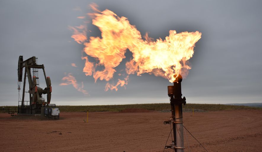 A flare burns natural gas at an oil well on Aug. 26, 2021, in Watford City, N.D. (AP Photo/Matthew Brown) **FILE**