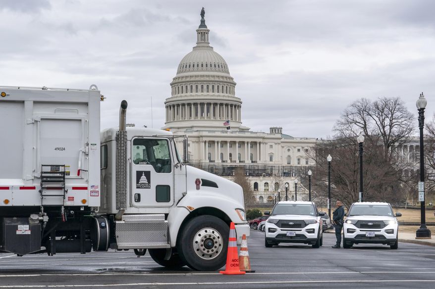 Heavy vehicles, including garbage trucks and snow plows, are set near the entrance to Capitol Hill at Pennsylvania Avenue and 3rd Street NW in Washington, Tuesday, Feb. 22, 2022, amid reports that trucker protests will arrive on March 1, the day of President Joe Biden&#x27;s State of the Union address. (AP Photo/J. Scott Applewhite)