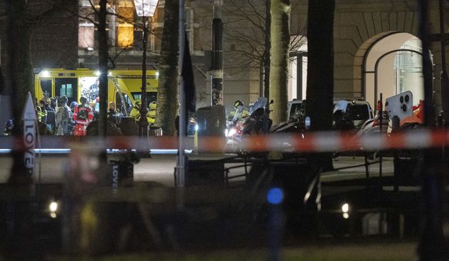 Police special intervention units and rescue workers are seen next to the Apple Store, two windows at right, in Amsterdam, Netherlands, Tuesday, Feb. 22, 2022, where an armed person was holed up in with at least one hostage in an hours-long standoff with scores of police massed outside. (AP Photo/Peter Dejong)