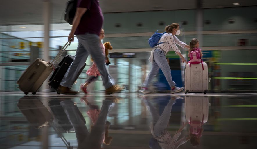 tourists arrive at Barcelona airport, Spain, Monday, June 7, 2021. European Union member countries agree they should further facilitate tourist travel into the 27-nation bloc for people who are vaccinated against the coronavirus or have recovered from COVID-19.  (AP Photo/Emilio Morenatti, File)