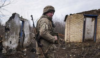 A Ukrainian serviceman stands at his position at the line of separation between Ukraine-held territory and rebel-held territory near Svitlodarsk, eastern Ukraine, Wednesday, Feb. 23, 2022. U.S. President Joe Biden announced the U.S. was ordering heavy financial sanctions against Russia, declaring that Moscow had flagrantly violated international law in what he called the &quot;beginning of a Russian invasion of Ukraine.&quot; (AP Photo/Evgeniy Maloletka)