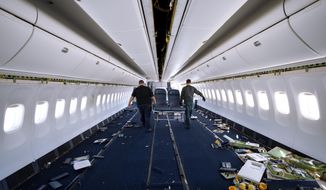 Engineers carry out passenger seats as they work on the conversion of a Boeing 767 passenger plane to a cargo plane at the Israel Aerospace Industries in Lod, near Tel Aviv, Israel, Feb. 13, 2022. With the global airline industry in a slump, Israel&#x27;s state-owned aerospace company is cashing in on the pandemic-driven growth in e-commerce by converting grounded passenger planes into cargo jets. (AP Photo/Oded Balilty)