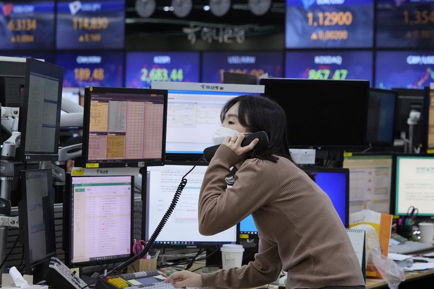A currency trader talks on the phone at the foreign exchange dealing room of the KEB Hana Bank headquarters in Seoul, South Korea, Thursday, Feb. 24, 2022. Asian stock markets followed Wall Street lower Thursday as anxiety about a possible Russian invasion of Ukraine rose. (AP Photo/Ahn Young-joon)
