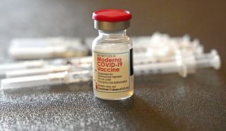 A vial filled with the Moderna COVID-19 vaccine rests by syringes waiting to be loaded by nurses from the Jackson-Hinds Comprehensive Health Center, at a vaccination station next to Jackson State University in Jackson, Miss., Tuesday, Dec. 7, 2021. (AP Photo/Rogelio V. Solis, File)