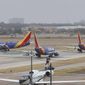 Southwest Airlines planes wait in line to take off from the Dallas Love Field Airport in Dallas, Wednesday, Feb. 23, 2022. (Lola Gomez/The Dallas Morning News via AP)
