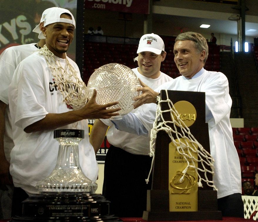 In this file photo taken April 2, 2002, Maryland basketball player Juan Dixon, left, jokes around with the Sears trophy with head coach Gary Williams, right, as assistant coach Jimmy Patsos, center, looks on during a ceremony to honor Maryland&#x27;s NCAA National Championship win over Indiana at Cole Field House in College Park, Md. At right foreground is the NCAA National Championship trophy. (AP Photo/Nick Wass, File) **FILE**