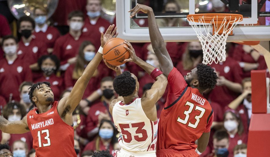 Maryland guard Hakim Hart (13) and forward Qudus Wahab (33) attempt to block a shot by Indiana guard Tamar Bates (53) during the first half of an NCAA college basketball game, Thursday, Feb. 24, 2022, in Bloomington, Ind. (AP Photo/Doug McSchooler)