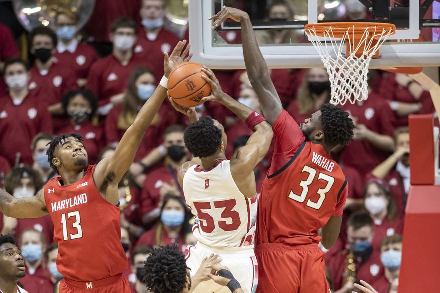 Maryland guard Hakim Hart (13) and forward Qudus Wahab (33) attempt to block a shot by Indiana guard Tamar Bates (53) during the first half of an NCAA college basketball game, Thursday, Feb. 24, 2022, in Bloomington, Ind. (AP Photo/Doug McSchooler)
