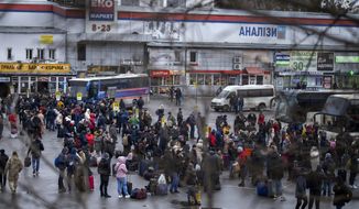 People try to get onto buses to leave Kyiv, Ukraine, Thursday, Feb. 24, 2022. (AP Photo/Emilio Morenatti)