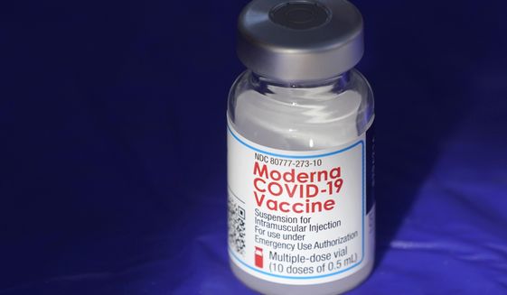 In this March 4, 2021 file photo, a vial of the Moderna COVID-19 vaccine rests on a table at a drive-up mass vaccination site in Puyallup, Wash., south of Seattle.  Moderna’s COVID-19 vaccine brought in nearly $7 billion in the final quarter of 2021, and the drugmaker says it has signed purchase agreements for another $19 billion in sales this year.   (AP Photo/Ted S. Warren, File)