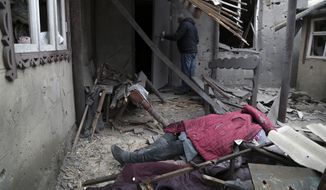 A body of woman from Ukraine, killed during shelling, lies under debris of a damaged house in Donetsk, in the territory controlled by pro-Russian militants, eastern Ukraine, Friday, Feb. 25, 2022. The Russian military is pressing its invasion of Ukraine to the outskirts of the capital. The advancement came after Russia unleashed airstrikes on cities and military bases and sent in troops and tanks from three sides in an attack that could rewrite the global post-Cold War security order. (AP Photo/Alexei Alexandrov)