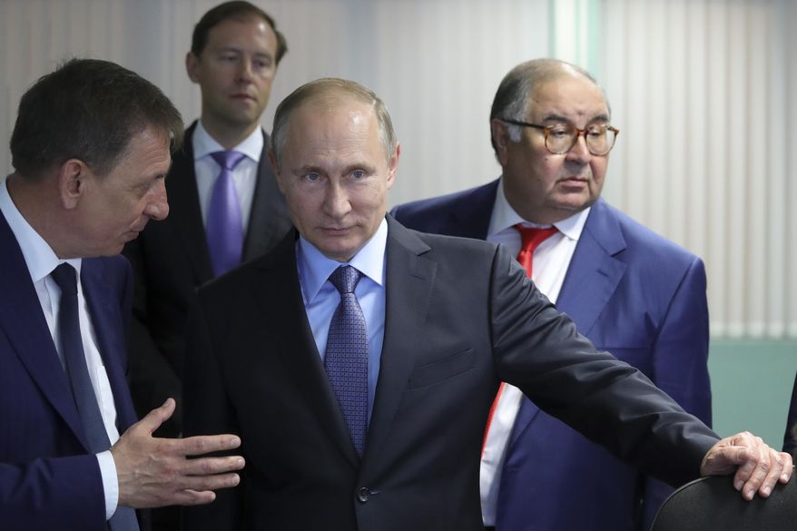 Russian President Vladimir Putin, center, listens to Lebedinsky GOK Managing Director Oleg Mikhailov, left, as businessman and founder of USM Holdings, Alisher Usmanov, right, and Minister of Industry and Trade Denis Manturov stand behind him while visiting the Lebedinsky GOK JSC, in Gubkin, Belgorod Region, Russia, Friday, July 14, 2017. Usmanov is not on the sanctions list implemented in response to the 2022 invasion of Ukraine. The metals tycoon was an early investor in Facebook. His fortune is estimated at more than $14 billion.  (Mikhail Klimentyev/Sputnik/Kremlin Pool Photo via AP, File)