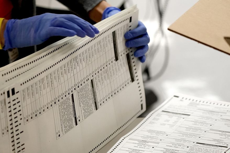 In this Nov. 4, 2020, file photo Maricopa County elections officials count ballots at the Maricopa County Recorder's Office in Phoenix. (AP Photo/Matt York, File)