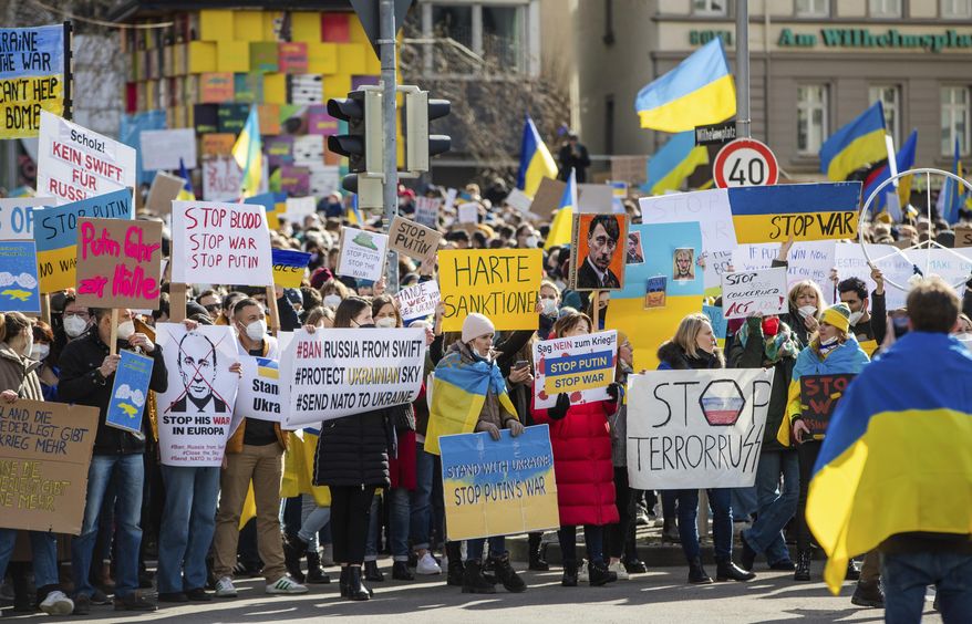 Numerous people demonstrate with signs and flags on Wilhelmsplatz in Stuttgart, Germany, against Russia&#39;s military deployment in Ukraine on Saturday, Feb. 26, 2022. (Christoph Schmidt/dpa via AP)