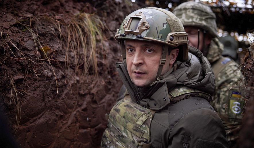 Ukrainian President Volodymyr Zelenskyy, walks under a camouflage net in a trench as he visits the war-hit Donetsk region, eastern Ukraine, Dec. 6, 2021. (Ukrainian Presidential Press Office via AP, File)
