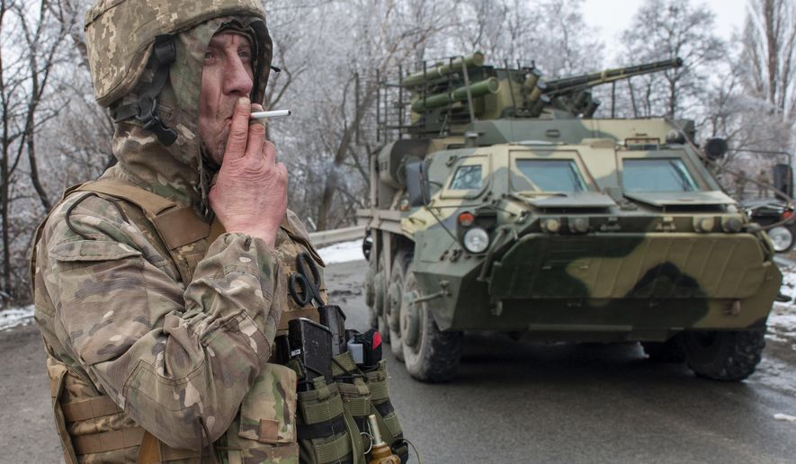 A Ukrainian soldier smokes a cigarette on his position at an armored vehicle outside Kharkiv, Ukraine, Saturday, Feb. 26, 2022. President Volodymyr Zelenskyy claimed Saturday that Ukraine's forces had repulsed the assault and vowed to keep fighting. "We will win," Zelenskyy said. (AP Photo/Andrew Marienko )