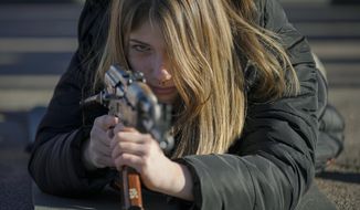 A young woman holds a weapon during a basic combat training for civilians, organized by the Special Forces Unit Azov, of Ukraine&#39;s National Guard, in Mariupol, Donetsk region, eastern Ukraine, Sunday, Feb. 13, 2022. (AP Photo/Vadim Ghirda)