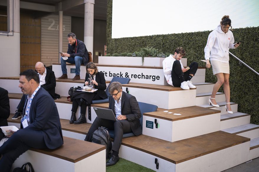 Visitors sit, have lunch and use smart phones and computers during the Mobile World Congress 2022 in Barcelona, Spain, Monday, Feb. 28, 2022. (AP Photo/Joan Mateu Parra) ** FILE **