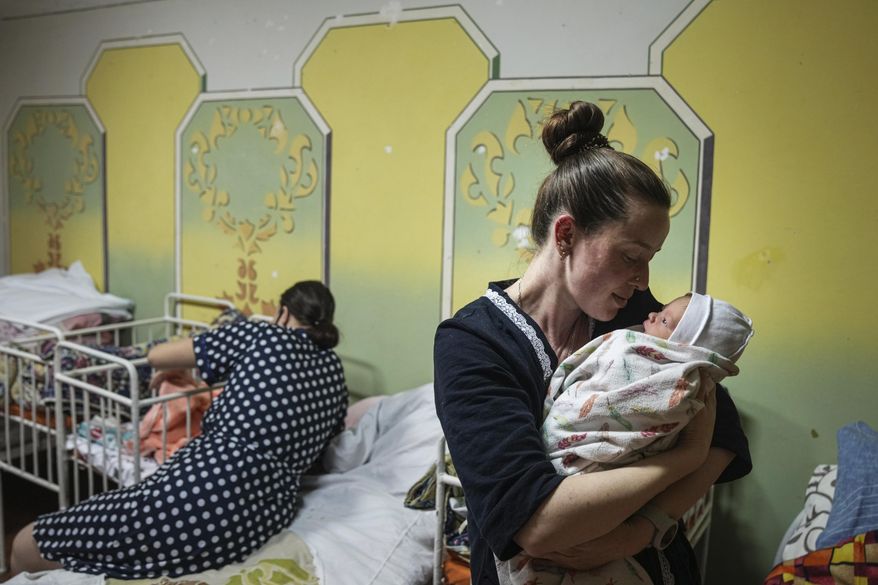 Kateryna Suharokova holds her newborn son Makar in the basement of a maternity hospital converted into a medical ward and used as a bomb shelter in Mariupol, Ukraine, Monday, Feb. 28, 2022. In makeshift shelters and underground railway platforms across Ukraine, families trying to protect the young and old and make conditions bearable amid the bullets, missiles and shells outside. (AP Photo/Evgeniy Maloletka)