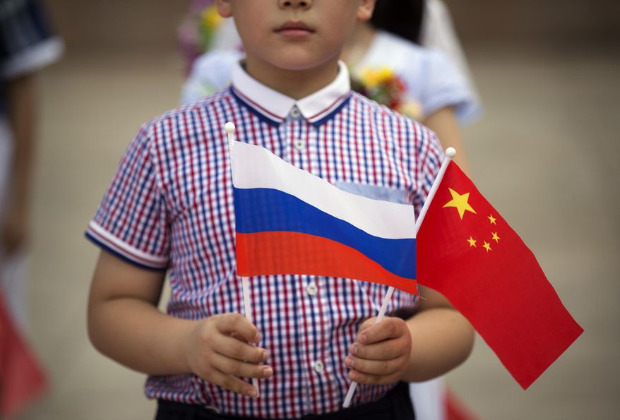 A boy holds Russian and Chinese flags before a welcoming ceremony for Russian President Vladimir Putin at the Great Hall of the People in Beijing on June 25, 2016. Three weeks ago, on the eve of the Beijing Winter Olympics, the leaders of China and Russia declared that the friendship between their countries &amp;quot;has no limits.&amp;quot; But that was before Russia&#39;s invasion of Ukraine, a gambit that will test just how far China is willing to go. (AP Photo/Mark Schiefelbein, File)