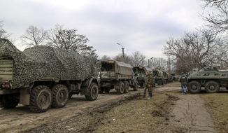 A convoy of military trucks parked in a street in Mykolaivka, Donetsk region, the territory controlled by pro-Russian militants, eastern Ukraine, Sunday, Feb. 27, 2022. Fighting also raged in two eastern territories controlled by pro-Russia separatists. (AP Photo)